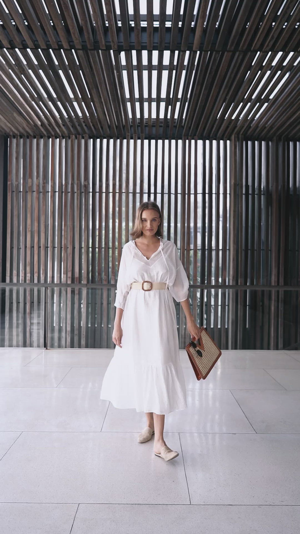 Model wearing white maxi dress holding Jenn Lee Tulum Tote