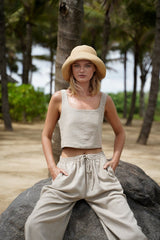 Model wearing straw hat, Jenn Lee Beige Linen Shell Top and Jenn Lee Beige Linen Drawstring pants